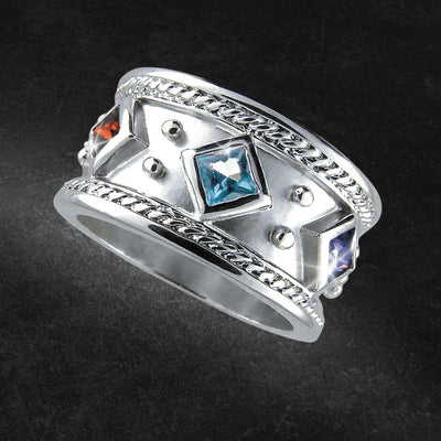 Amora Ring crafted from sterling silver featuring a wide band with intricate braided edges and three square-cut gemstones in blue, orange, and purple, designed for female jewelry enthusiasts.