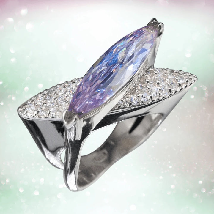 Blue Sculpture Ring featuring a sterling silver design with rhodium plating, showcasing an elongated blue gemstone accented by sparkling clear crystals, for women’s jewelry.