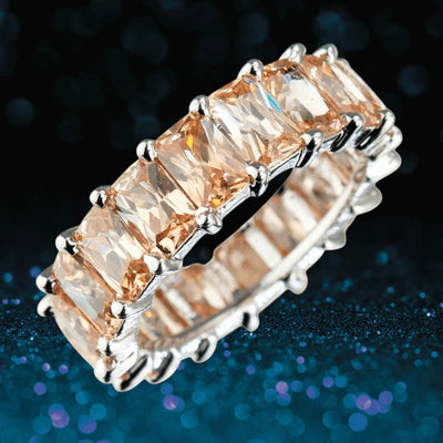 Champagne Forever Baguette Eternity Ring featuring rectangular champagne gemstones set in sterling silver with rhodium plating, designed for women’s jewelry collections.