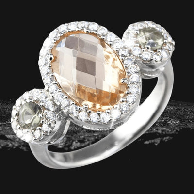 Vernaison Champagne Ring featuring a sterling silver band with a large faceted champagne-colored center stone surrounded by smaller clear stones, designed for females.