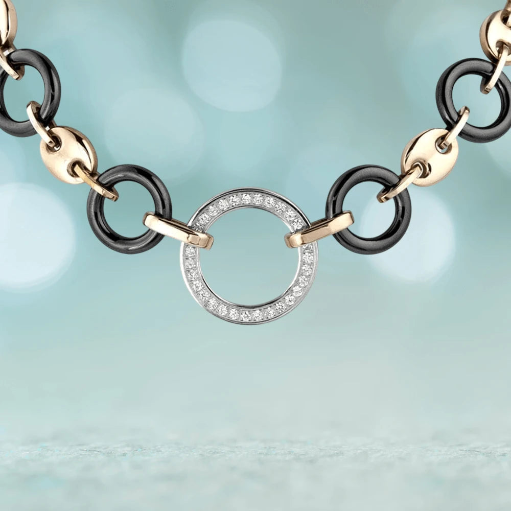Close-up of the Java Ceramic Halo Necklace featuring a rose gold and stainless steel chain with black ceramic links and a circular pendant encrusted with crystals, designed for women’s jewelry.