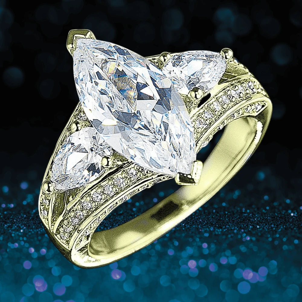 Millionaire Marquise Gold Ring featuring a sterling silver band plated in gold with a large marquise-cut center stone flanked by two triangular stones and smaller accent stones.