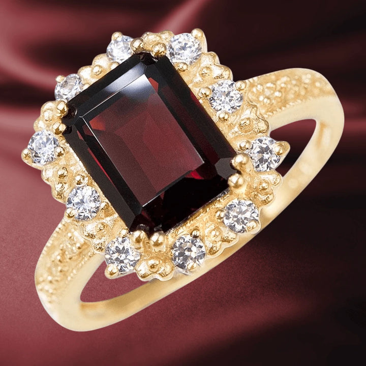 Genoa Garnet Ring featuring a rectangular garnet centerpiece set in gold-plated sterling silver with sparkling clear stones surrounding the gemstone, designed for female jewelry collectors.