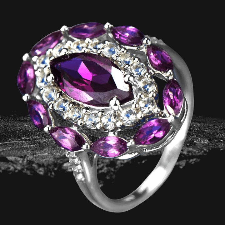 Rhodolite Rhapsody Ring featuring a sterling silver band plated in rhodium, adorned with marquise-cut deep purple rhodolite stones and clear accent gems, designed for women.