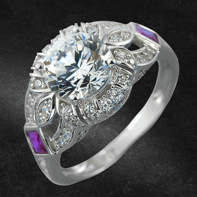 Heirloom Ring featuring a large central sparkling gemstone, crafted in sterling silver with rhodium plating, adorned with smaller clear stones and two purple accents for an elegant female jewelry piece.