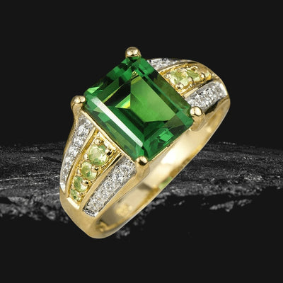 Belvedere Ladies Ring featuring a large rectangular green gemstone set in sterling silver with gold plating, accented by smaller green and clear stones for an elegant look.