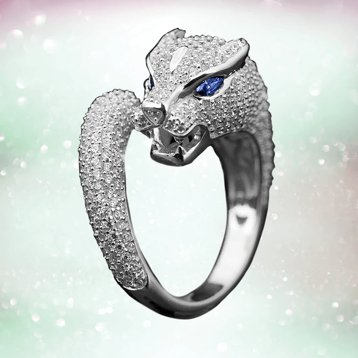 Panther Rhodium Ring in sterling silver with rhodium plating, featuring a detailed panther head design accented by blue gemstone eyes and sparkling stones.