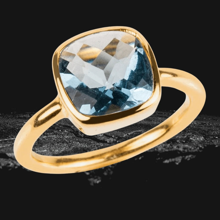 Dream Gems Ring Blue Topaz featuring a sterling silver band plated with gold, showcasing a cushion-cut blue topaz gemstone designed for female jewelry lovers.