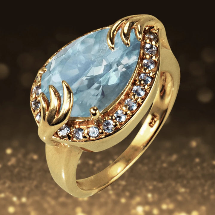 Aqua Pear Ring featuring a pear-shaped aquamarine gemstone set in sterling silver with gold plating, surrounded by sparkling small crystals, designed for women.