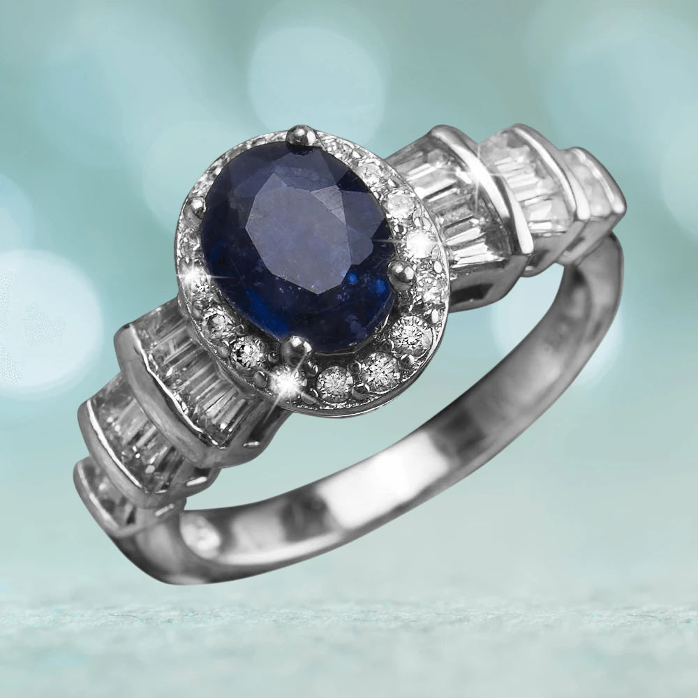 Blue Symphony Ring featuring a sterling silver band with rhodium plating, showcasing a deep blue oval gemstone surrounded by sparkling clear stones, designed for female wear.