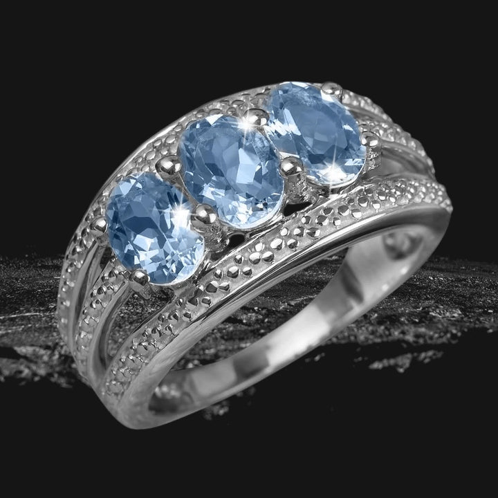 Blue Aqua Ring featuring three sparkling blue aqua stones set in sterling silver with rhodium plating, designed for a refined and elegant female jewelry collection.