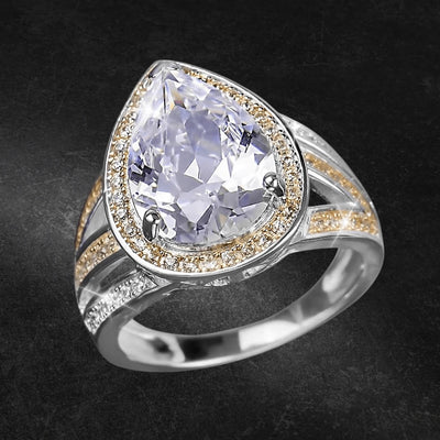 Charisma Ring featuring a two-tone sterling silver band with a large pear-shaped clear gemstone surrounded by smaller sparkling stones, designed for females.