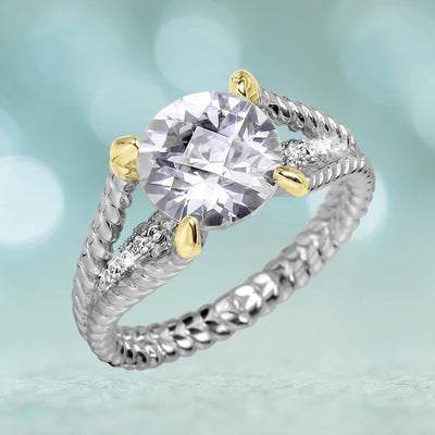 Solitaire Delight Ring featuring a two-tone sterling silver band with a textured design and a sparkling round solitaire stone held by gold accents, elegant female jewelry.
