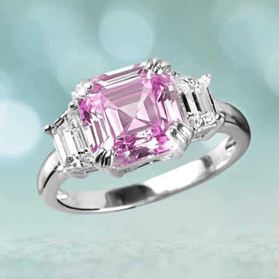 Asscher Pretty In Pink Ring featuring a sterling silver band with rhodium plating, showcasing a pink Asscher-cut center stone flanked by two clear trapezoid gemstones.