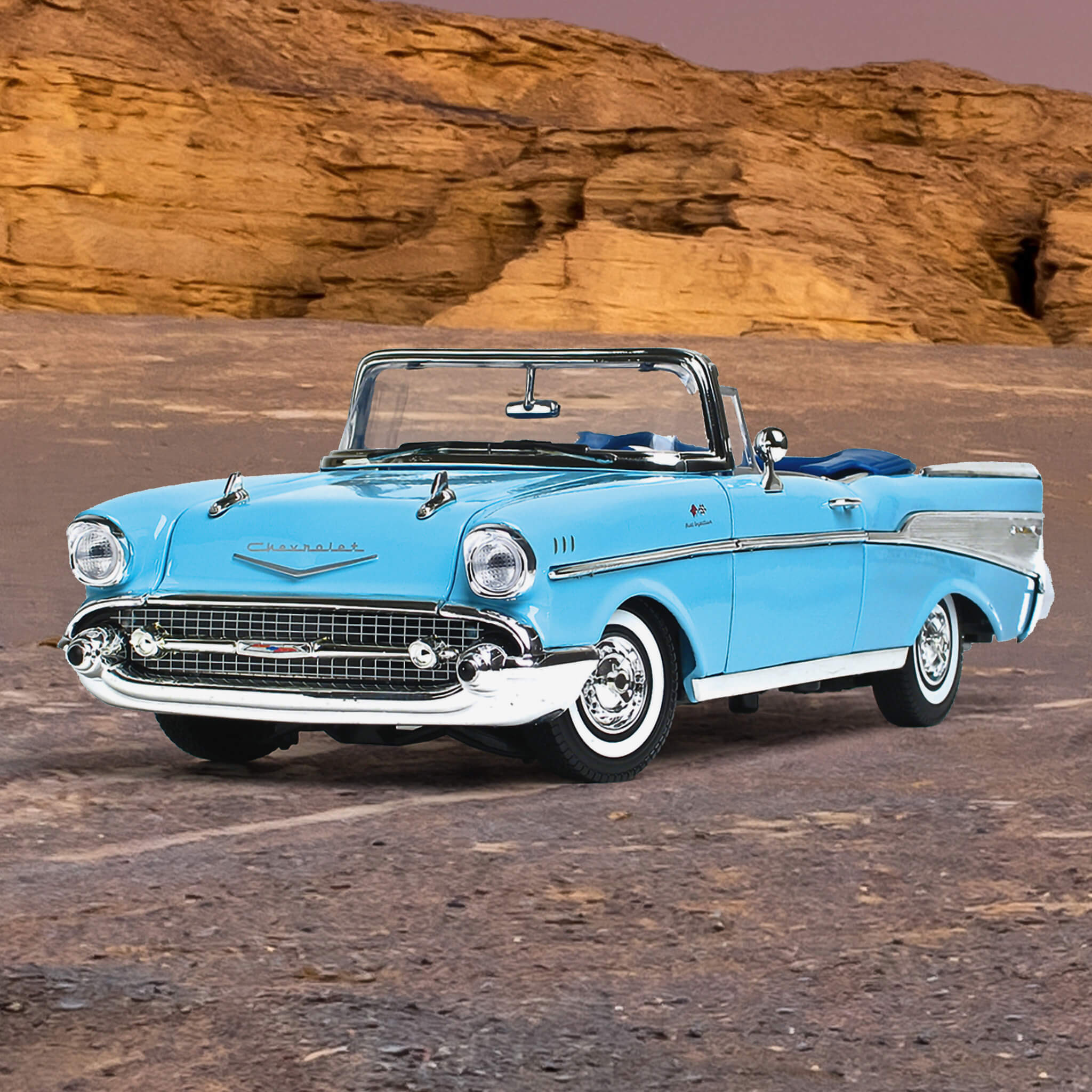 1957 Chevy Bel Air - Larkspur Blue convertible classic car parked on desert terrain with rocky cliffs in the background under a clear sky