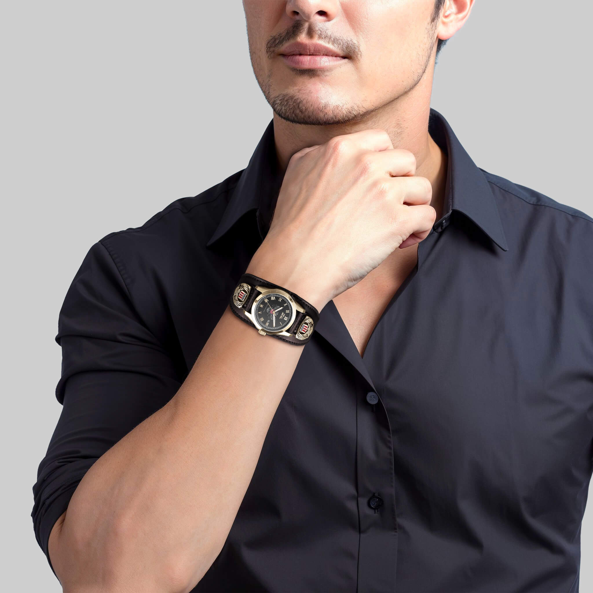 Man wearing a Patriot Men's Watch with a black dial, gold plating, and stainless steel material, paired with a black dress shirt in a professional setting.