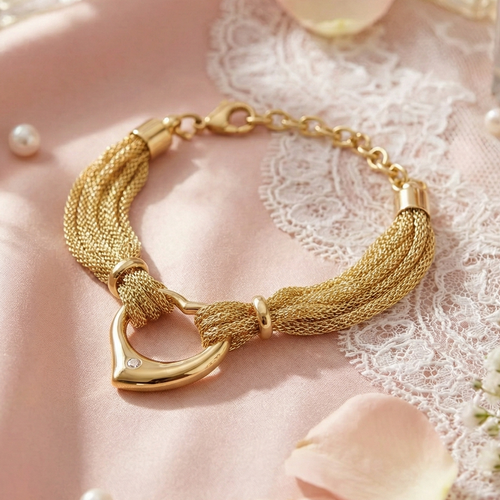 Gold bracelet on a pink surface with flowers and perfume bottles