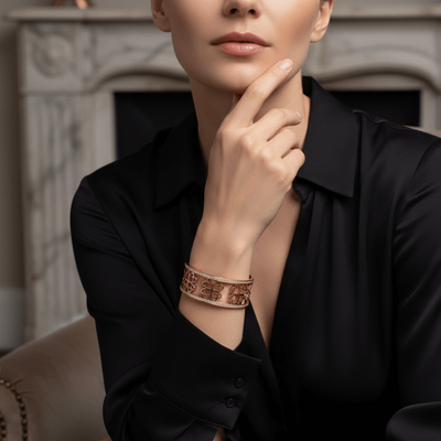 Woman wearing a black shirt with a decorative bracelet, sitting in a cozy room. She is wearing a rose gold bangle