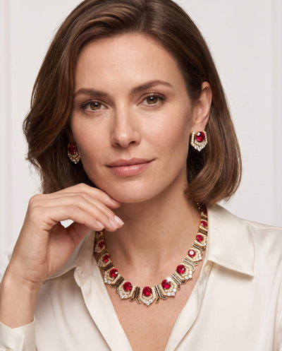 Portrait of a woman wearing Scarlet Heirloom Earrings with matching necklace, showcasing elegant jewelry with red stones and gold accents, Up To 75% Off Retail.