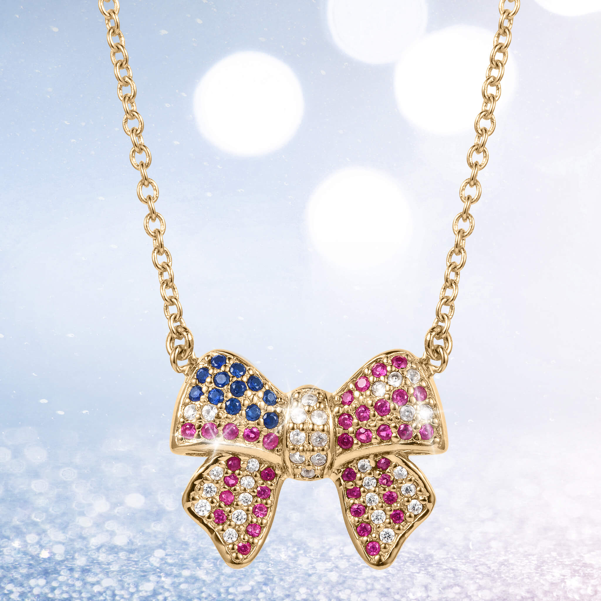 Delicate Heritage Bow Necklace featuring a gold-tone bow pendant adorned with blue, pink, and clear sparkling stones on a fine chain, perfect for elegant jewelry lovers.