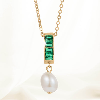 Pearl Radiance Pendant featuring a gold chain with a rectangular gold setting adorned with four green gemstones and a single white pearl drop pendant.