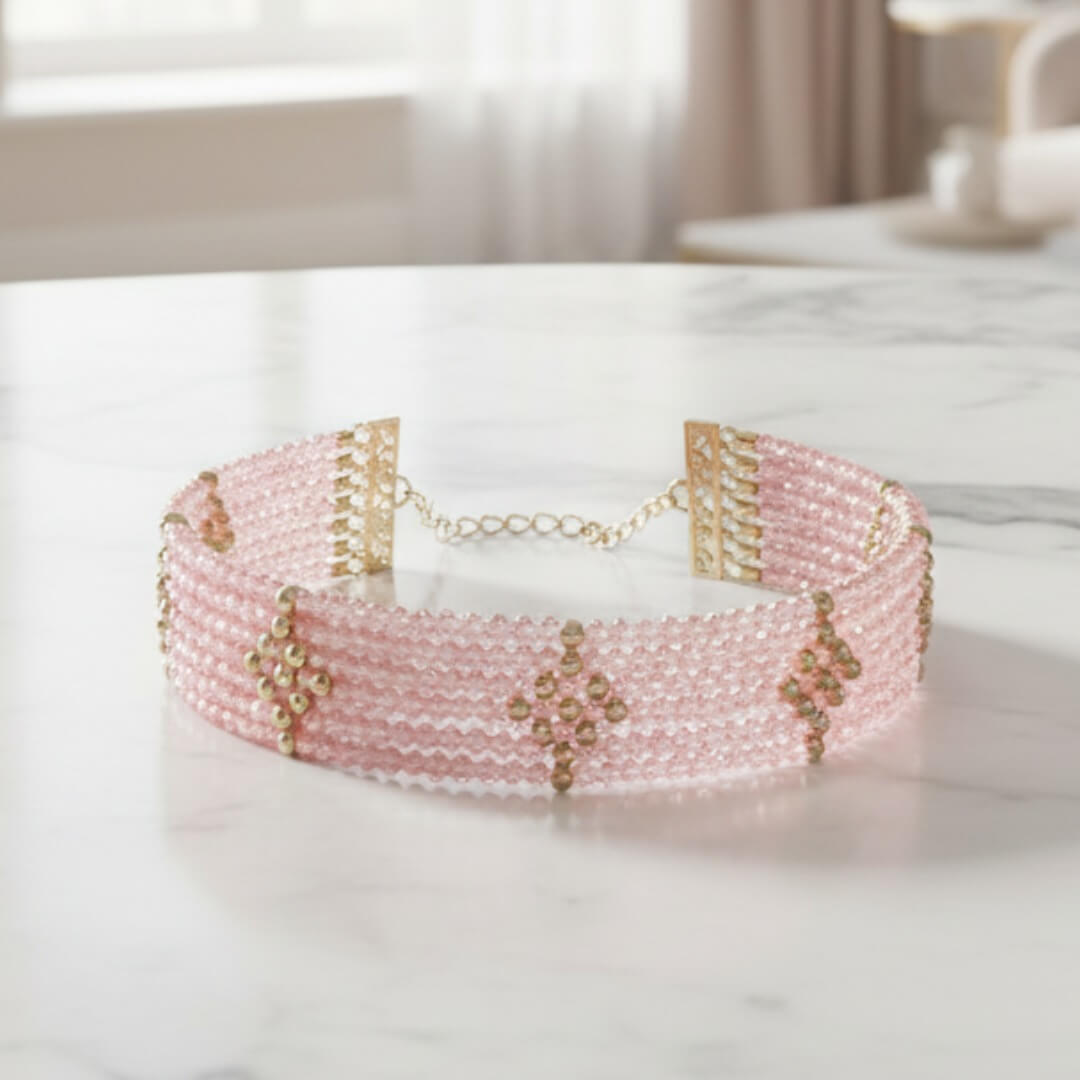 Pink beaded headband with gold accents on a white surface. Rosa Cascade Bracelet