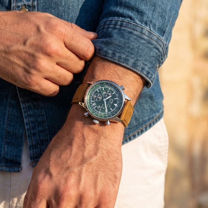 Close-up of a man adjusting a Legacy Chrono Men's Watch with a green dial and tan leather strap, showcasing a stylish and durable timepiece for everyday wear.