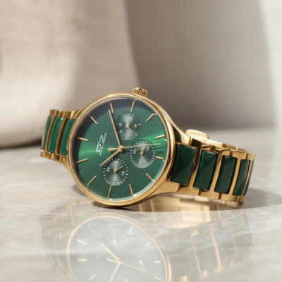 Green watch with gold band on a reflective surface. Daniel Steiger Verde Ceramic Men's Watch