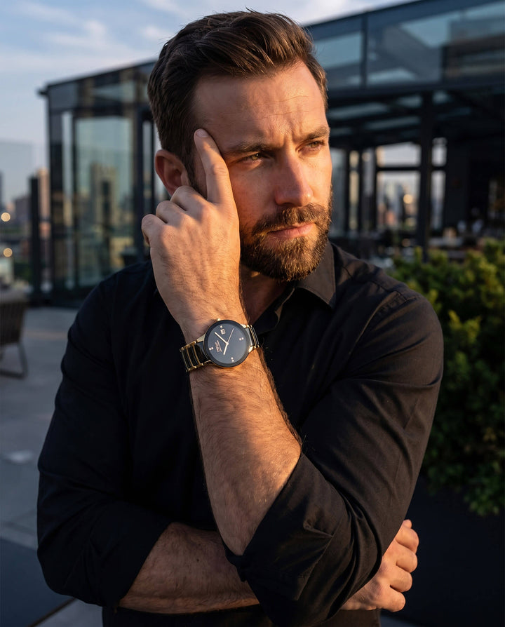 Man wearing a black shirt and watch, standing outdoors with a cityscape background