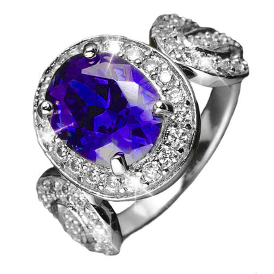 Olivia Ring featuring a sterling silver band plated in gold, adorned with a vibrant purple gemstone surrounded by sparkling clear crystals, designed for female jewelry lovers.