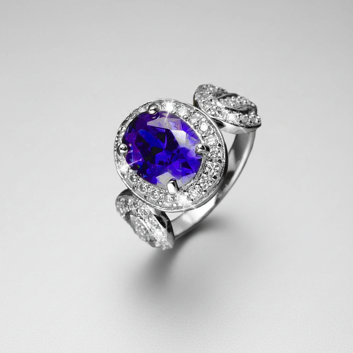 Olivia Ring featuring a sterling silver band with gold plating, adorned with a large purple gemstone centerpiece surrounded by sparkling clear stones, designed for females.