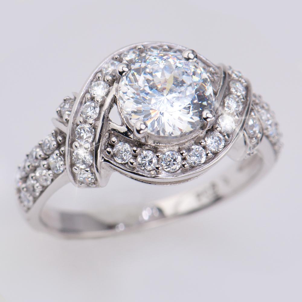 Lover's Knot Ring in sterling silver with rhodium plating featuring a large central clear gemstone surrounded by smaller sparkling stones in an elegant knot design for women.