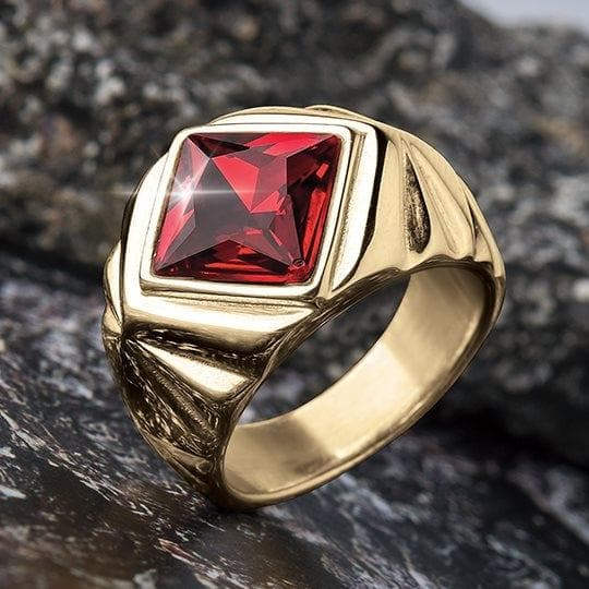 Obsedia Men's Ring featuring a bold gold-plated stainless steel band with a striking square red gemstone centerpiece, designed as an elegant men's jewelry piece.