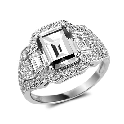 Close-up of The Elizabeth Ring featuring a sterling silver band with rhodium plating, set with an emerald-cut center stone and accented by rectangular side stones and small pavé diamonds.